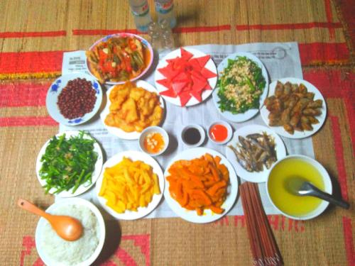 a bunch of food on a table with plates of food at Tày Cốc Pảng Homestay in Làng Cac
