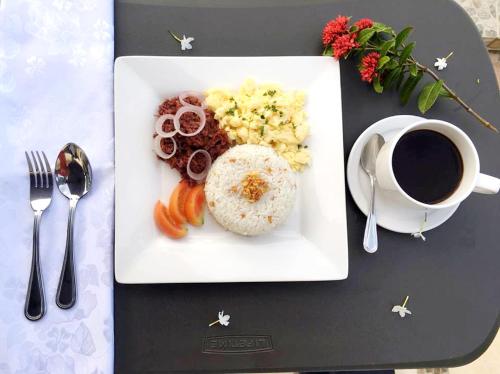 Un plato de comida en una mesa con una taza de café. en Cawit Resort and Cafe, en Islas Camotes
