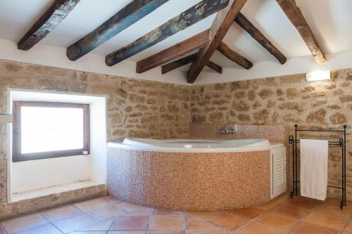 un ampio bagno con vasca e finestra di Hotel Can Simo a Alcudia