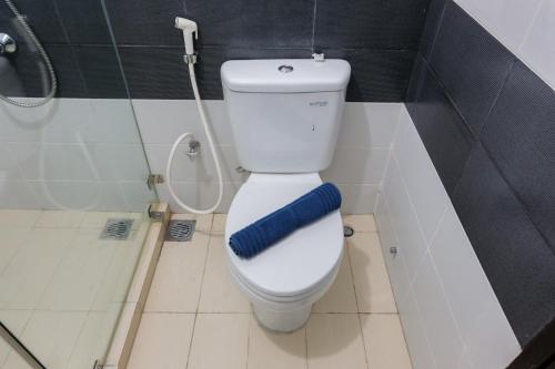 a bathroom with a toilet with a blue towel on it at Brand New Cozy Studio at Scientia Apartment By Travelio in Tangerang