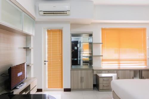 a kitchen with orange blinds on the windows at Brand New Cozy Studio at Scientia Apartment By Travelio in Tangerang