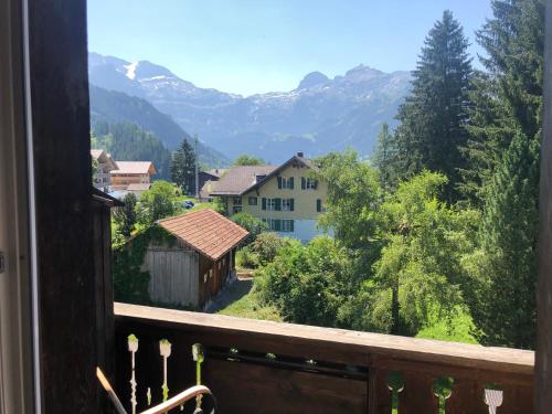 a balcony with a view of a village and mountains at Ferienlenk Mountain Village in Lenk