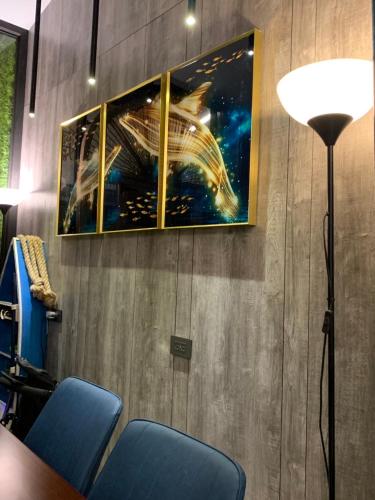 a picture hanging on a wall with blue chairs at Long To Sea Again in Hualien City