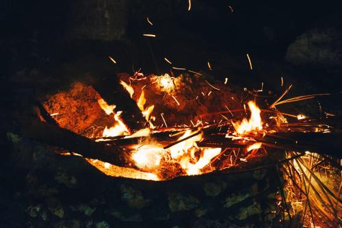 a large bonfire with flames in the dark at Sunlit Hostel in General Luna