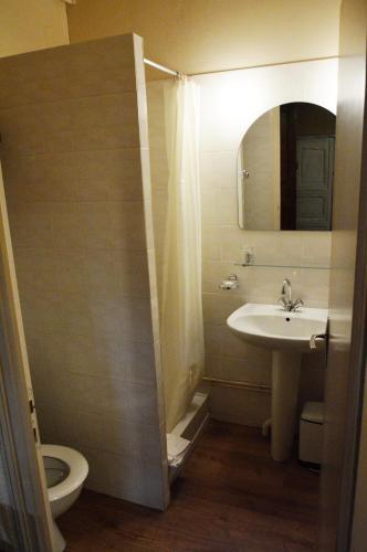 une salle de bain avec un lavabo, des toilettes et un miroir dans l'établissement Les gîtes du bourg, à Vitrac