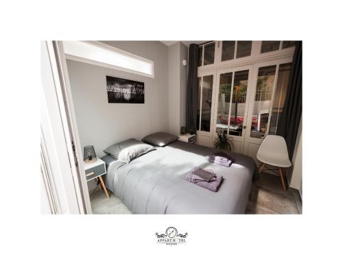 une petite chambre avec un lit et une fenêtre dans l'établissement La Suite T2 40m2 avec terrasse 1ch-4pers Appart Hotel Poitiers, à Poitiers