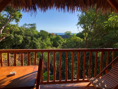 a wooden deck with a table and a chair on it at JJ ET EUPHRASIE Lodge in Nosy Be