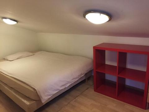 a small bedroom with a bed and a red cabinet at CHAPELLE ST NICOLAS in Roanne