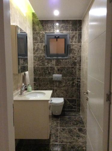 uma casa de banho com um lavatório e uma televisão na parede em Salamis Park em Famagusta