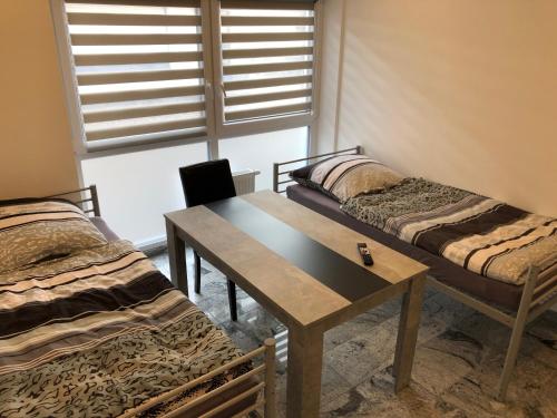 a room with two beds and a table and a window at Industriestraße in Belm in Belm
