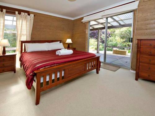 a bedroom with a large bed and a sliding glass door at Kingfisher in Margaret River Town