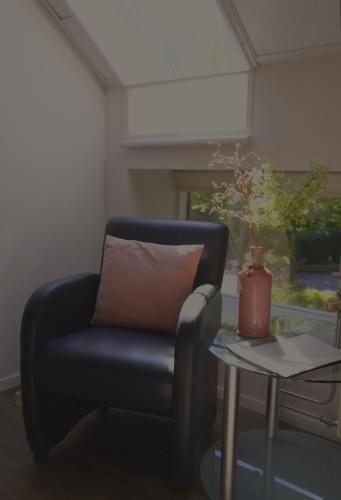 a blue chair sitting next to a table with a vase at Hotel Lemmenhof in Ell