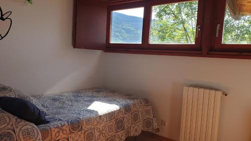 um quarto com uma cama, uma janela e um radiador em Ca l'ESTRELLA em Queralbs