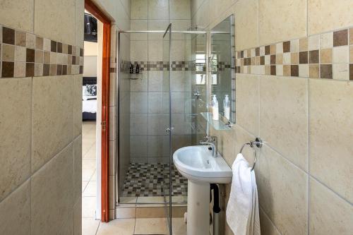 a bathroom with a sink and a shower at Kiyala Guest Farm in Nelspruit