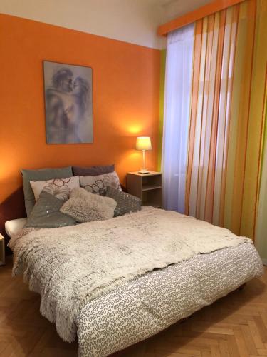 Un dormitorio con una cama con una pared naranja. en Apartmán Orchidej u Vřídla, en Karlovy Vary