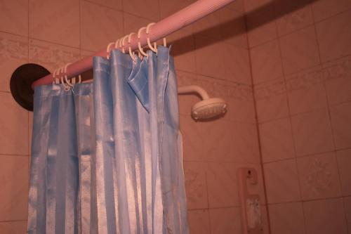 a blue shower curtain hanging in a bathroom at Leinmach House Nyali in Mombasa