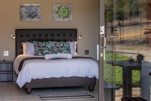 a bedroom with a bed and a sliding glass door at Kiyala Guest Farm in Nelspruit