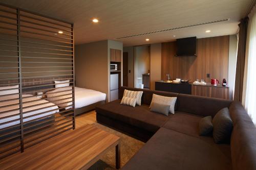 a living room with a couch and a bedroom at Hakone Yutowa in Hakone