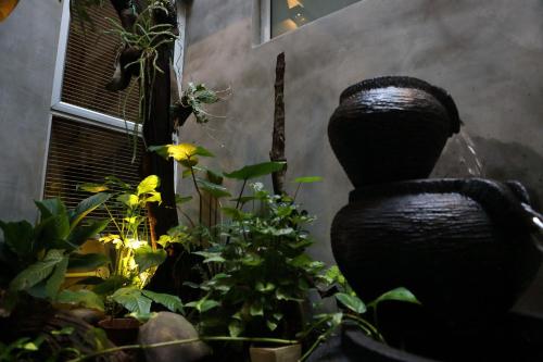 a garden with plants and a water fountain at De House Hotel in Sibu