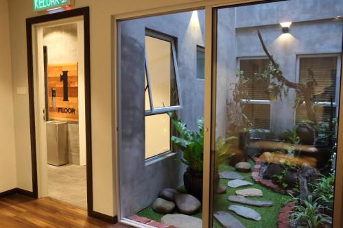 a room with a sliding glass door with a garden at De House Hotel in Sibu