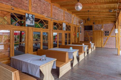 a restaurant with tables and chairs in a building at Pavilon Panzió Étterem és Pizzéria in Gyomaendrőd