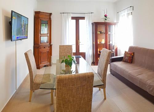 ein Wohnzimmer mit einem Glastisch und Stühlen in der Unterkunft Casa Gina Garden and view by Gardadomusmea in Tremosine sul Garda