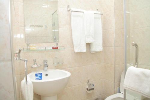a bathroom with a sink and a toilet and towels at ART Palace in Tashkent