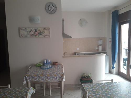 a kitchen with a table and a clock on the wall at G&G - Bed & Breakfast in Vieste