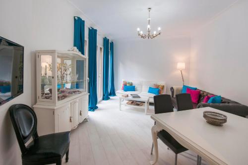 a living room with blue curtains and a table and chairs at Cason del Corpus in Toledo