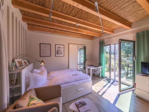 a bedroom with a bed and a living room at Ferienhaus Kleine Sommerliebe in Warenshof