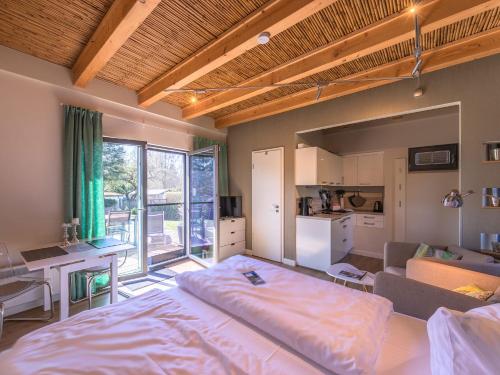 a bedroom with a large bed and a living room at Ferienhaus Kleine Sommerliebe in Warenshof