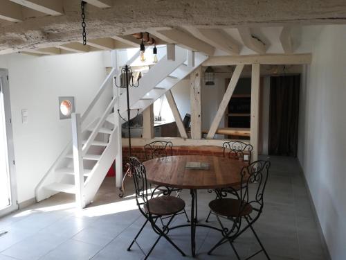 a table and chairs in a room with stairs at Chez Flo in Ry