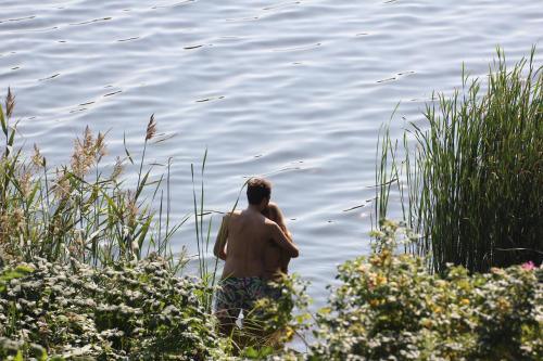 a man standing in a body of water at Ferienhaus direkt am Schmalensee in Schmalensee