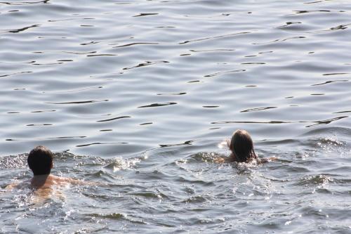 a man and a woman swimming in the water at Ferienhaus direkt am Schmalensee in Schmalensee