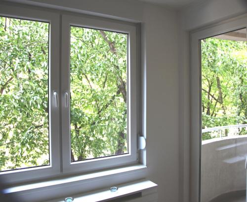a window in a room with a view of a tree at River View Nis - 65 square meters Designer Apartment in heart of city Park for free in Niš