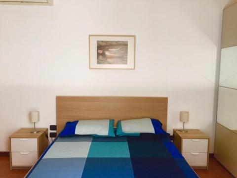 um quarto com uma cama azul com duas mesas de cabeceira em Casa Mariù em Palermo
