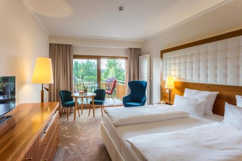 a hotel room with a bed and a table and chairs at Hotel & Spa Der Steirerhof in Bad Waltersdorf