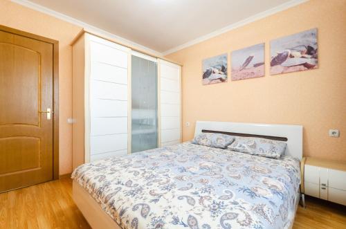 a bedroom with a bed with a blue and white comforter at ARTAL Apartment on Obolonskaya Square 3 in Kyiv