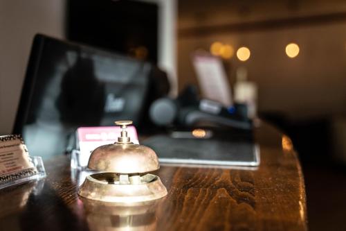 a close up of a bell on a desk with a laptop at Hotel Löwenstein in Gerolstein