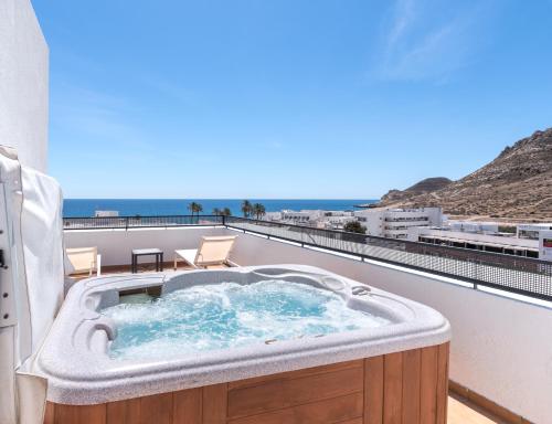 a hot tub on a balcony with a view of the ocean at Hotel Calachica Las Negras in Las Negras