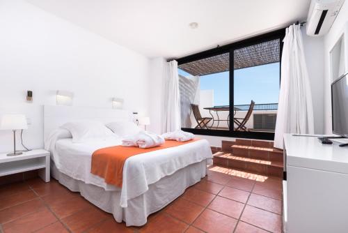 a bedroom with a bed and a large window at Hotel Calachica Las Negras in Las Negras