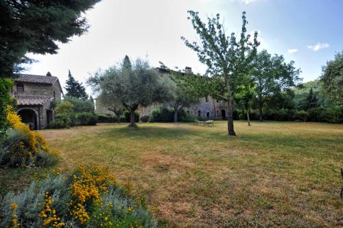 a large yard with a house and trees at La Casa nel Castello di Gaiche in Piegaro