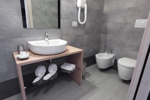 a bathroom with a sink and a toilet at Motel Karibe in Fratta Polesine
