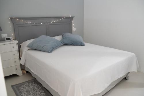 a bedroom with a white bed with two pillows on it at Acquabianca in Aci Castello