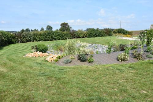 a garden with rocks and plants in a field at Chambres d'hôtes de L'orval in Thiergeville