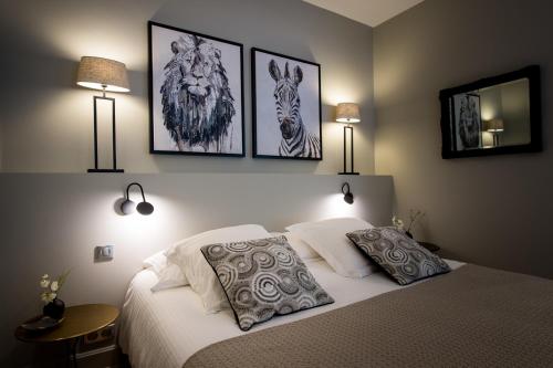 um quarto com uma cama com três fotografias na parede em La Suite d'Elisabeth em Sarlat-la-Canéda