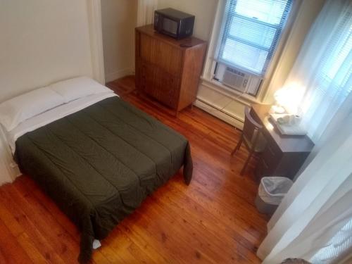 ein Schlafzimmer mit einem Bett und einem TV auf einer Kommode in der Unterkunft Cappuccio Hotel in Keansburg