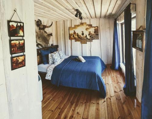 a bedroom with a blue bed in a room at Rancho Zapotoczny in Łagów