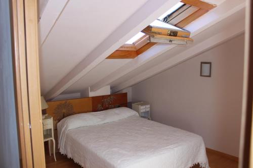 1 dormitorio con 1 cama blanca en el ático en Duplex para 6 en Cercs, Berga - A 30 mins del Pedraforca, en Sant Corneli de Cercs 