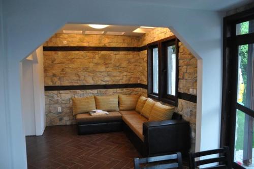 a living room with a couch against a brick wall at Panorama Complex in Tvŭrditsa